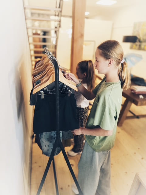 2 meisjes die merk kleding uitzoeken in winkel