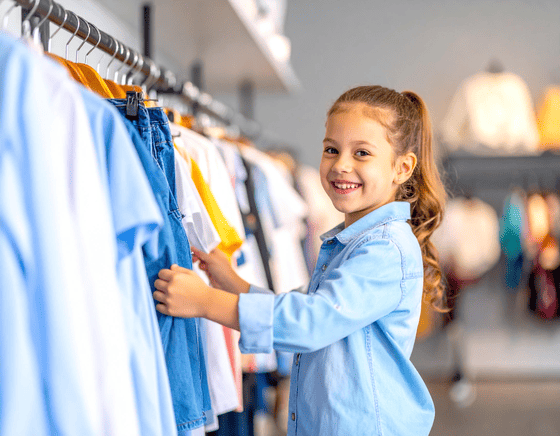 Meisje die duurzame merkkleding uitzoekt in winkel